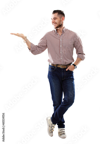 Photo: Happy smiling young man presenting text or product isolated Happy smiling young man presenting text or product isolated