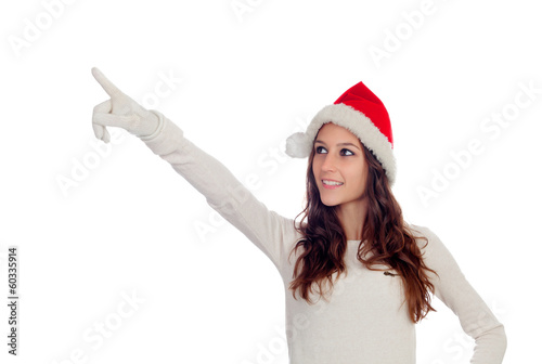 Photo: Attractive casual girl with Christmas hat pointing something Attractive casual girl with Christmas hat pointing something