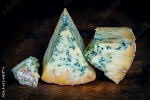 Photo: Stilton mature blue mouldy cheese - Dark background Stilton mature blue mouldy cheese - Dark background