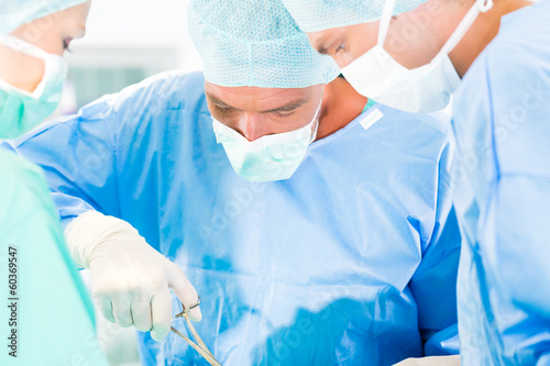 Photo: Chirurgen operieren in OP-Saal an Patienten Chirurgen operieren in OP-Saal an Patienten