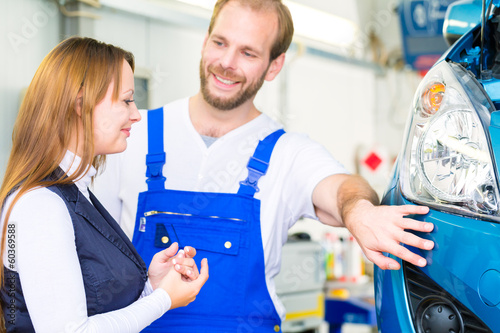 Photo: Kundin und Mechaniker an Auto in Werkstatt Kundin und Mechaniker an Auto in Werkstatt