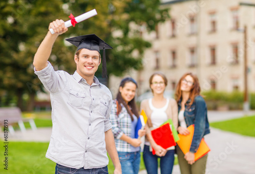 Photo: smiling teenage boy in corner-cap with diploma smiling teenage boy in corner-cap with diploma