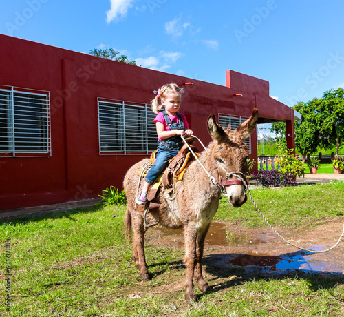 Photo: child riding a miniature donkey child riding a miniature donkey
