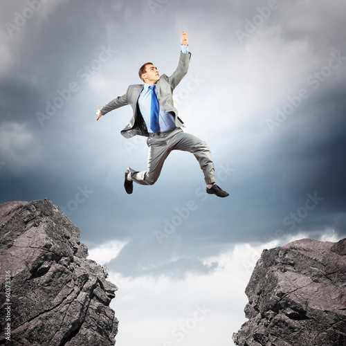 Photo: Businessman jumping over gap Businessman jumping over gap