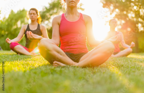 Photo: horizontal of a group of women doing yoga at sunset with flare horizontal of a group of women doing yoga at sunset with flare