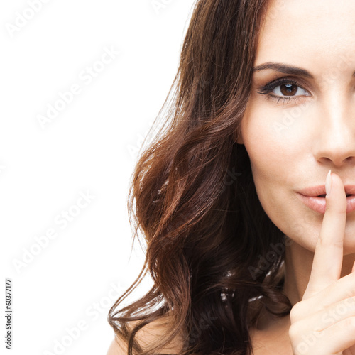 Photo: Woman with finger on lips, on white Woman with finger on lips, on white