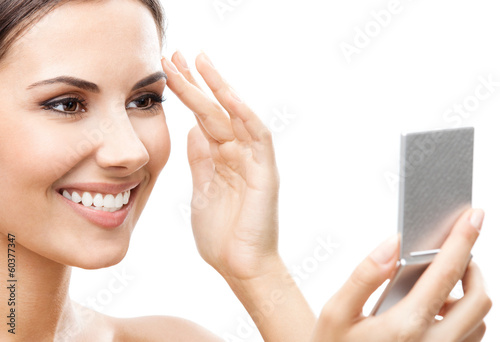 Photo: Woman looking at mirror, isolated over white Woman looking at mirror, isolated over white