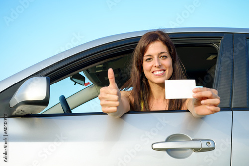 Photo: Successful girl in car with driving license Successful girl in car with driving license