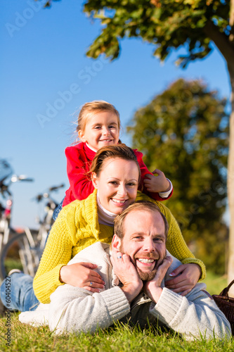 Photo: Familie beim Ausflug mit dem Fahrrad im Park Familie beim Ausflug mit dem Fahrrad im Park