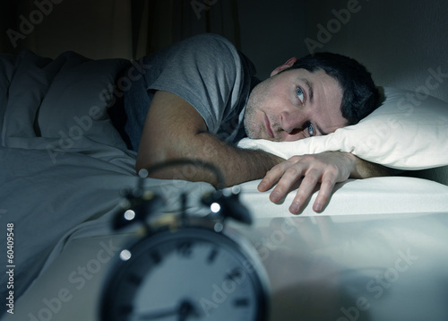 Photo: man in bed with eyes opened suffering insomnia sleep disorder man in bed with eyes opened suffering insomnia sleep disorder