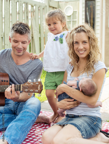 Photo: Father playing guitar on a family picnic Father playing guitar on a family picnic