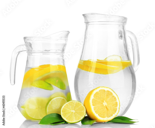 Photo: Cold water with lime, lemon and ice in pitchers isolated Cold water with lime, lemon and ice in pitchers isolated