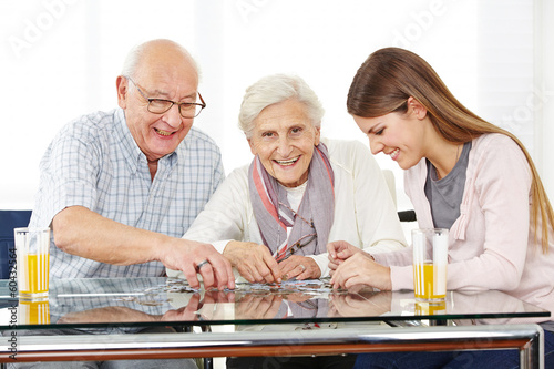 Photo: Paar Senioren löst Puzzle mit Enkeltochter Paar Senioren löst Puzzle mit Enkeltochter