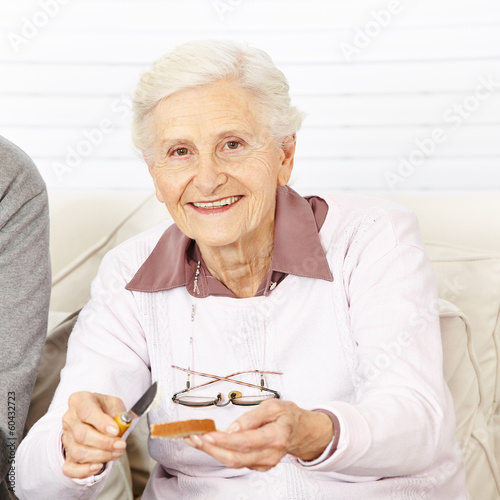 Photo: Alte Frau schmiert Brot zum Frühstück Alte Frau schmiert Brot zum Frühstück
