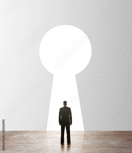 Photo: businessman looking to keyhole businessman looking to keyhole