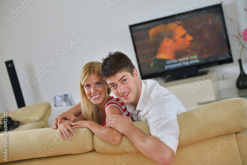 Photo: Relaxed young couple watching tv at home Relaxed young couple watching tv at home
