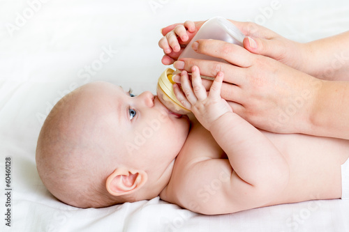 Photo: mother feeding by milk her baby infant from bottle mother feeding by milk her baby infant from bottle
