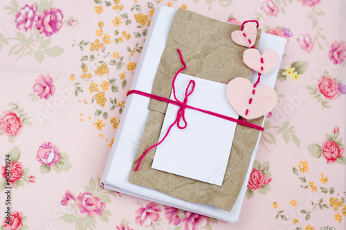 Photo: Old notebook for love notes on floral background Old notebook for love notes on floral background