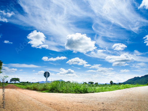 Photo: rural crossroad green grass and blue sky rural crossroad green grass and blue sky