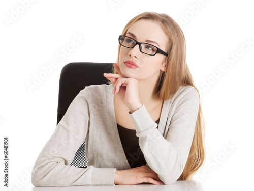 Photo: Portrait of beautiful thoughtful woman in eyeglasses sitting. Portrait of beautiful thoughtful woman in eyeglasses sitting.