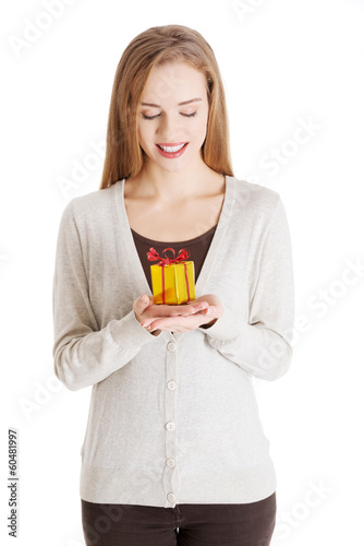 Photo: Beautiful casual woman holding small present in hands. Beautiful casual woman holding small present in hands.