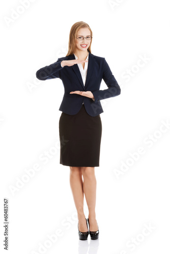 Photo: Beautiful business woman holding empty copy space between her ha Beautiful business woman holding empty copy space between her ha