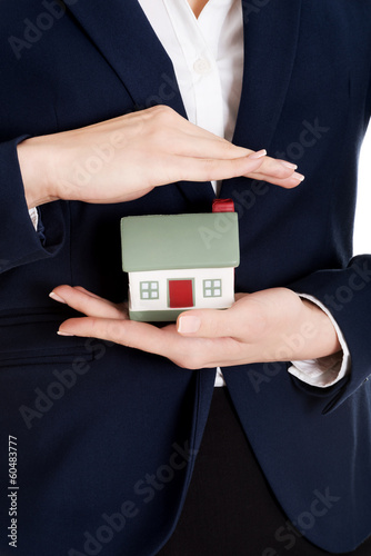 Photo: Close up on house modal in business woman's hands. Close up on house modal in business woman's hands.