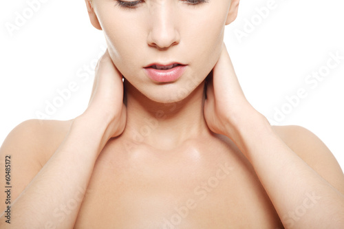 Photo: Naked woman touching her neck, head and shoulders close up. Naked woman touching her neck, head and shoulders close up.