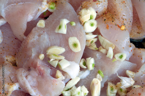 Photo: Sliced chicken meat with spice and garlic in cooking process Sliced chicken meat with spice and garlic in cooking process