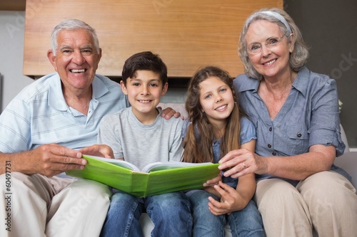 Photo: Portrait of grandparents and grandkids looking at album photo Portrait of grandparents and grandkids looking at album photo