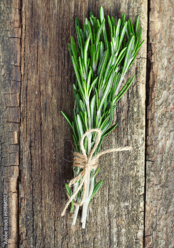 Photo: bunch of rosemary on wooden surface bunch of rosemary on wooden surface