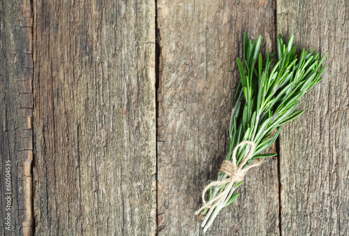 Photo: bunch of rosemary on wooden surface bunch of rosemary on wooden surface