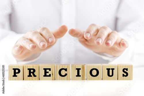 Photo: Mans hands protecting the word Precious Mans hands protecting the word Precious