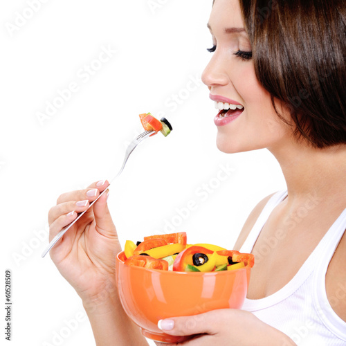 Photo: Young woman eats vegetable Young woman eats vegetable