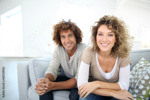 Photo: Sweet couple relaxing at home in sofa Sweet couple relaxing at home in sofa