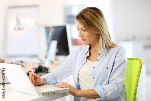 Photo: Smiling businesswoman working in office Smiling businesswoman working in office