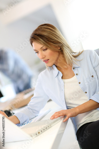 Photo: Smiling businesswoman working in office Smiling businesswoman working in office