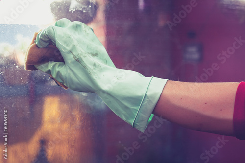 Photo: Hand wearing rubber glove is cleaning windows Hand wearing rubber glove is cleaning windows