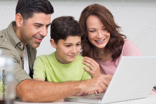 Photo: Smiling couple with son using laptop Smiling couple with son using laptop