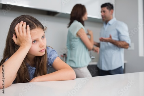 Photo: Closeup of a sad girl while parents quarreling Closeup of a sad girl while parents quarreling