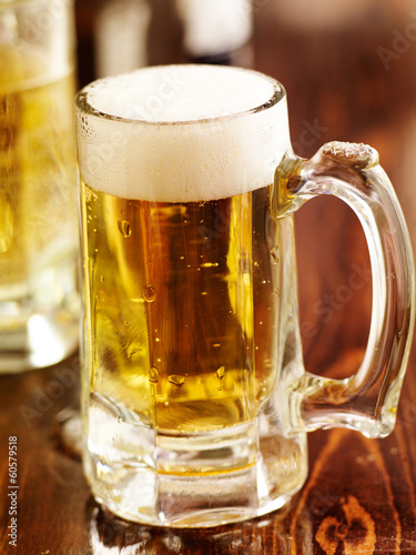 Photo: large mug of beer on wood counter large mug of beer on wood counter