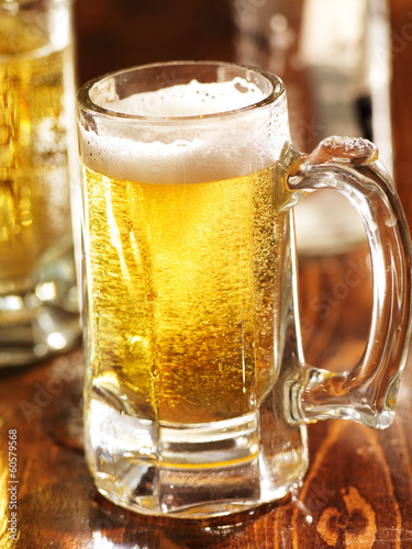 Photo: large mug of beer on wood counter large mug of beer on wood counter