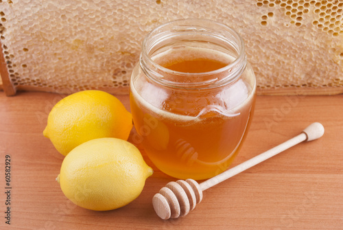 Photo: Fresh honey in a glass jar and lemons. Fresh honey in a glass jar and lemons.