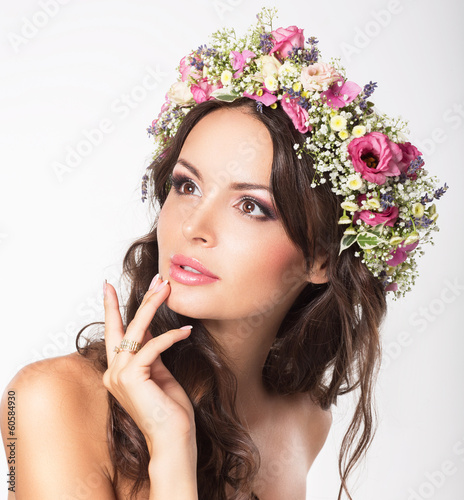 Photo: Young Beauty. Woman's Face with Bouquet of Natural Flowers Young Beauty. Woman's Face with Bouquet of Natural Flowers