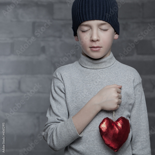 Photo: Serious boy holding heart, studio Serious boy holding heart, studio