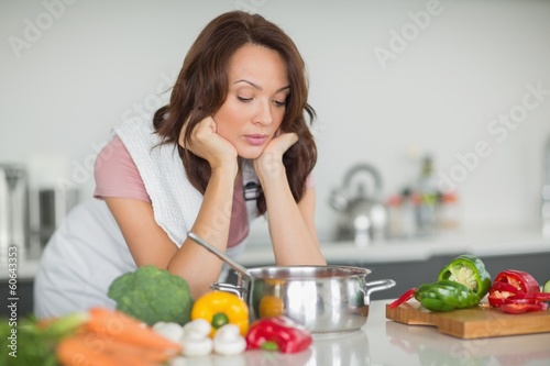 Photo: Serious woman preparing food in kitchen Serious woman preparing food in kitchen