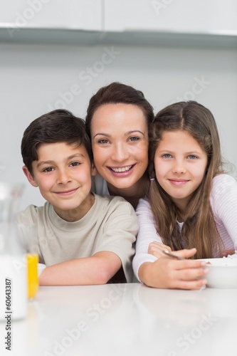 Photo: Closeup of a smiling mother with kids in kitchen Closeup of a smiling mother with kids in kitchen