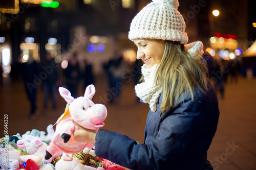 Photo: Young woman looking toys at street Young woman looking toys at street