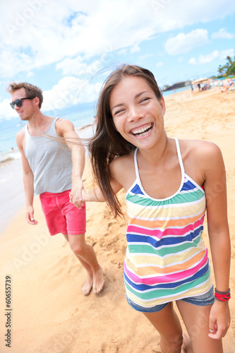 Photo: Beach people - young couple holding hands walking Beach people - young couple holding hands walking