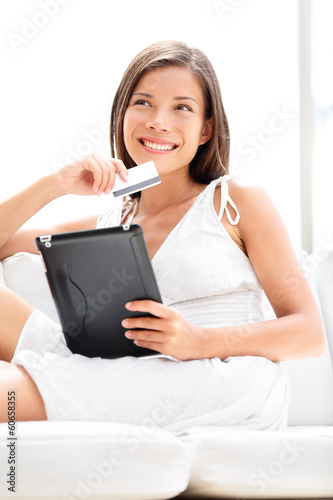 Photo: Woman shopping on tablet computer with credit card Woman shopping on tablet computer with credit card